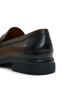 Brown leather shoe with a glossy smooth finish, rounded shape, black rubber sole, stitched accents, and a low heel.