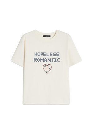 Maglietta a maniche corte color crema con la scritta "HOPELESS ROMANTIC" sopra una piccola grafica a forma di cuore decorata con motivi floreali.