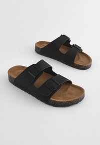 Sorte sandaler med to justerbare spænder, kork-agtig tekstureret sål, faux suede overdel og en polstret brun fodseng.