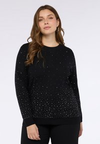 Maglione nero con scollo rotondo, maniche lunghe e una sfumatura di decorazioni tono argento che creano un effetto scintillante.