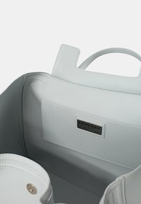 Borsa tote in pelle bianca con superficie testurizzata, caratterizzata da una forma rettangolare, doppi manici e un'etichetta che recita "ERMANNO." L'interno è spazioso.