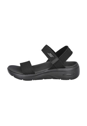 Sandalias negras con correas de malla y suela contorneada, que cuentan con un acento ArchFit, diseñadas para la comodidad y el soporte.