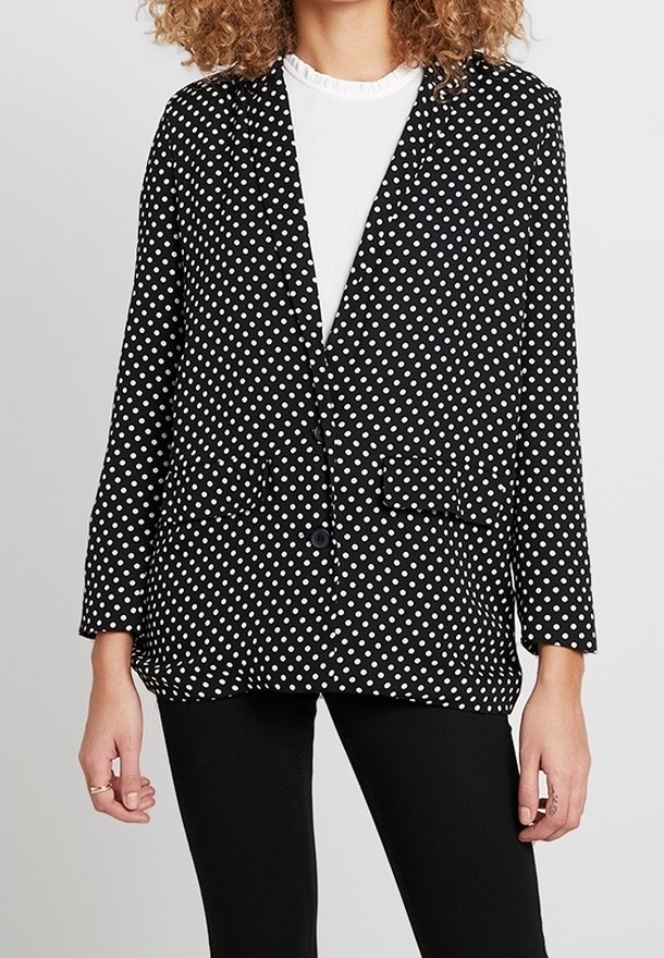 Czarna marynarka w białe grochy, z długimi rękawami, klapami z wycięciami, dwoma przednimi kieszeniami i pojedynczym zapięciem na guzik. Gładka faktura tkaniny.