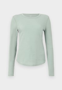 Ανοιχτό πράσινο ριμπ μακρυμάνικο μπλουζάκι με στρογγυλή λαιμόκοψη και στρογγυλεμένη ραφή στο τελείωμα, εμφανιζόμενο σε λευκό φόντο.