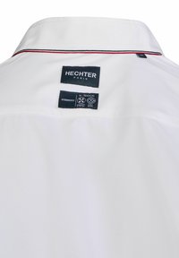 Witte colbert met rode accenten. Bevat merklabels en verzorgingslabels die op de achterkant zijn genaaid. Moderne pasvorm met een gladde textuur.