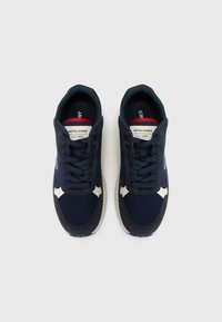 Marine sneakers i mesh og ruskind, snørebåndsdesign, hvide detaljer og en polstret sål. Brandingen er synlig på tungen.
