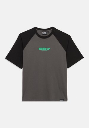 T-shirt à manches courtes avec manches noires et corps gris foncé, avec le logo vert EA7 Emporio Armani sur la poitrine et une petite étiquette près de l'ourlet.