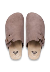 Sabots en daim marron à forme arrondie, avec une bride réglable munie d'une boucle métallique, et des semelles intérieures beiges ornées d'un logo noir.