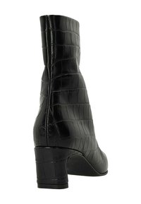 Schwarze High Heel Stiefelette mit strukturiertem Krokodil-Muster, glattem Leder und eckiger Zehenpartie.