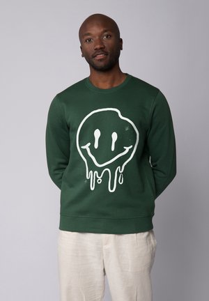 Green sweatshirt made of cotton, featuring a large white dripping smiley face graphic on the front and ribbed neckline and cuffs.