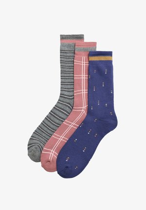 Tres pares de calcetines: grises a rayas, rosas con un patrón de cuadros y azules con puntos de colores. Cada uno tiene una tela suave y puños sólidos.
