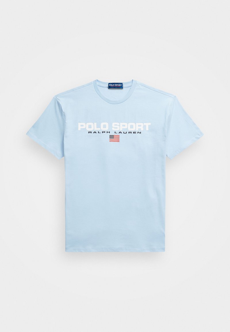 T-shirt en coton bleu clair avec un col rond, présentant "POLO SPORT" et "RALPH LAUREN" en texte blanc, ainsi qu'un petit graphique du drapeau américain.