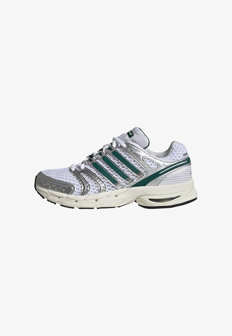 Chaussure de sport blanche avec des accents argentés, dotée d'une tige en mesh, de trois bandes vertes sur le côté et d'une semelle amortie.