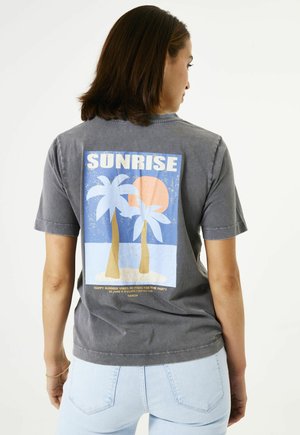 Grijze katoenen t-shirt met een grafische print van palmbomen en een zon, met het woord "SUNRISE" in vetgedrukte witte tekst. Korte mouwen, relaxed fit.