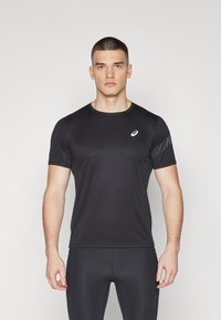 Svart sport t-shirt med korta ärmar, tillverkad av ett elastiskt, slätt material med ett subtilt mönster på höger axel.