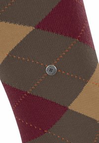 Skarpetki w wzór argyle w odcieniach brązu, burgundowego i beżowego. Wykonane z teksturowanej tkaniny z kontrastującym pomarańczowym przeszyciem oraz okrągłym metalowym logo.