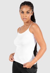 Weißes, figurbetontes Tanktop mit dünnen Trägern und rundem Ausschnitt, aus glattem Stoff gefertigt, im schlanken Schnitt gestaltet.