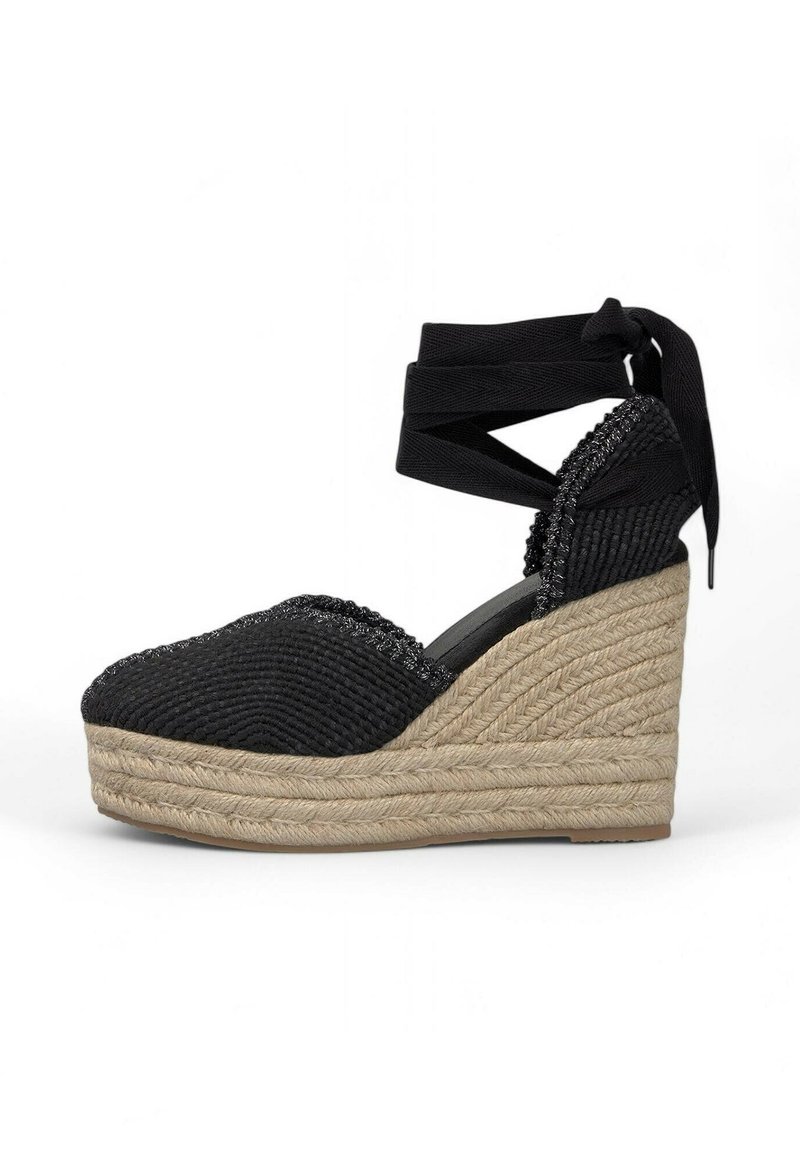 Espadrilles nere a zeppa con texture intrecciata, lacci alla caviglia e una plataforma in juta. Presentano una punta arrotondata e cucitura decorativa lungo la parte superiore.