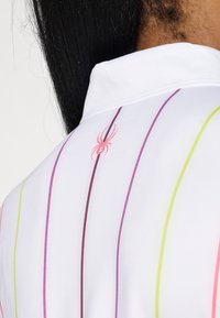 White collared shirt with vertical stripes in pink, purple, and green. Features a small pink spider logo on the back. Smooth, lightweight fabric.