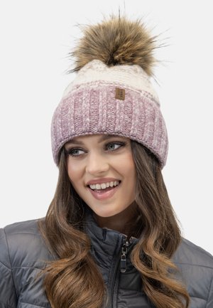 Knit beanie in pinks and cream, featuring a large faux fur pom-pom on top and a ribbed texture, with a small leather brand tag.