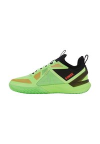 Zapatillas deportivas verdes con una parte superior de malla texturizada, acentos negros y detalles en naranja. Presentan una suela de goma con un patrón de banda de rodadura en zigzag.