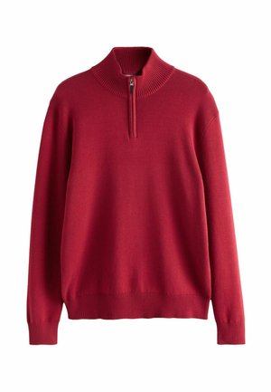 Punane poolpika varrukaga sviiter, millel on kõrge soonikkoes kaelus ja pool-kinnitus. Omab pikki varrukaid ning soonikkoes mansette ja allserva, mis loovad vormitud ilme.