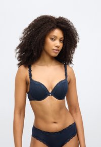 Σουτιέν σε ναυτικό μπλε με δαντέλα στο τελείωμα, λεπτομέρεια με στρογγυλό σύρμα και μικρά σχέδια με καρδούλες. Ταιριαστό εσώρουχο με δαντέλα.