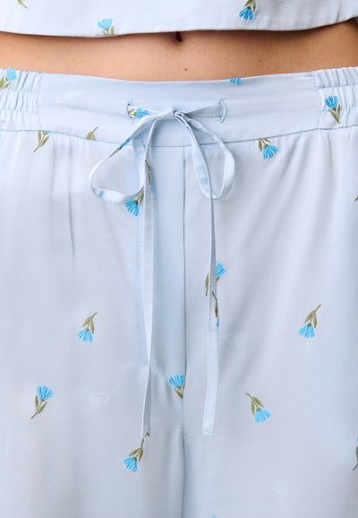 Completo da notte azzurro chiaro composto da un top corto e pantaloni, con delicati fiori blu ricamati e un dettaglio di coulisse in vita.