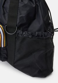 Fekete nylon táska ráncolt tetejével és hálós oldalzsebbel. Csíkozott anyagú kiemelésekkel és strapabíró hordozó pánttal rendelkezik.