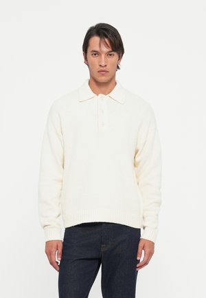 Cream-colored pullover sweater with a polo collar, three buttons, ribbed cuffs, and hem. Soft textured material; relaxed fit.