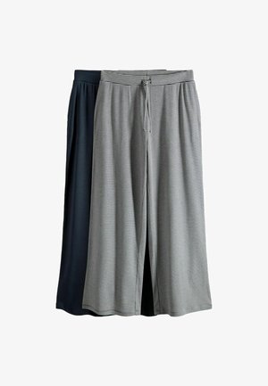 Twee paar wijde broekspijpen, één effen zwart en één met dunne zwart-witte horizontale strepen en een taille met trekkoord.