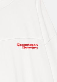Hvid sweatshirt med en glat tekstur, der har rød broderet tekst "København Danmark" på tværs af forsiden.