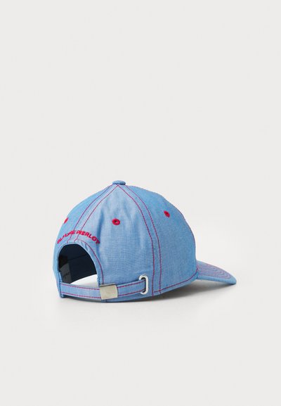 Cappellino blu denim con cuciture rosse, fascia posteriore regolabile e logo ricamato. Visiera curva e fori di ventilazione sulla corona per una migliore traspirabilità.