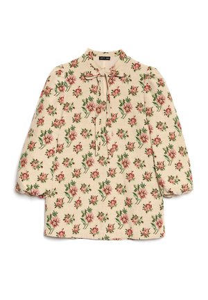 Blouse fleurie à manches bouffantes, fond crème, motif floral détaillé rose et vert, col avec lien et tissu texturé.