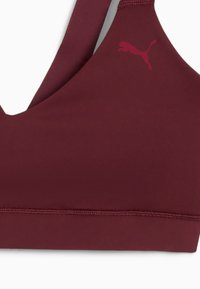 Bordo sportski grudnjak s dizajnom u obliku slova V, izrađen od glatkog materijala. Ima izvezeni logo u gornjem lijevom kutu i ojačane šavove.