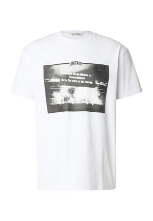 Hvit T-skjorte med svart-hvitt grafikk som viser en stadionscene med røyk, og ordet "UNFAIR" over bildet.