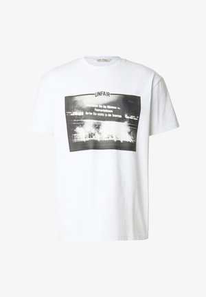 Hvit T-skjorte med svart-hvitt grafikk som viser en stadionscene med røyk, og ordet "UNFAIR" over bildet.