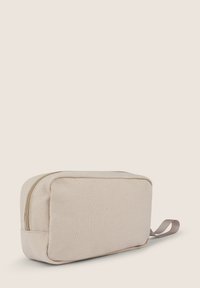 Borsa cosmetica in tela beige di forma rettangolare, con chiusura a zip e una maniglia laterale per un facile trasporto. Texture liscia e design minimale.
