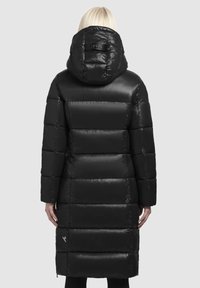 Black puffer coat with a shiny finish, hood, and horizontal quilted sections. Features a logo patch near the hem.