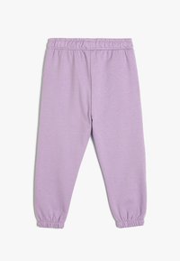 Pantalones de chándal lavanda hechos de una tela suave, con cintura elástica y puños elásticos en los tobillos, de textura suave y sin patrones.