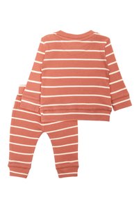 Ensemble en deux pièces rayé, comprenant un haut à manches longues et un pantalon. Texture côtelée douce en terracotta atténué avec des rayures blanches.