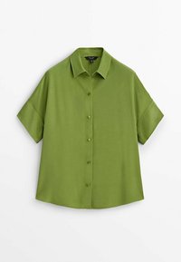 Chemise à manches courtes en olive uni, fabriquée en tissu lisse, avec un col classique et une coupe décontractée.