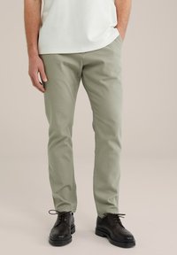 Pantaloni din bumbac verde deschis, cu o croială dreaptă, având un finisaj texturat. Asortați cu pantofi drepți maro închis cu siret.