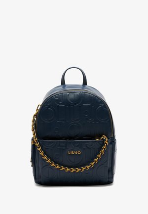 Sac à dos en cuir bleu marine avec motif de logo embossé, accent en chaîne dorée, forme arrondie et poignée supérieure. Dispose d'un compartiment principal zippé.