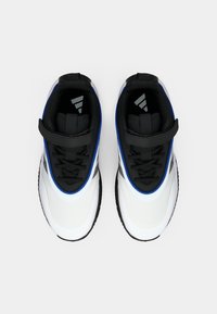 Černobílé sportovní boty s modrými akcenty, texturovaný síťovaný svršek, zabezpečené zapínání na pásek a gumová podrážka s vzorovaným profilem.