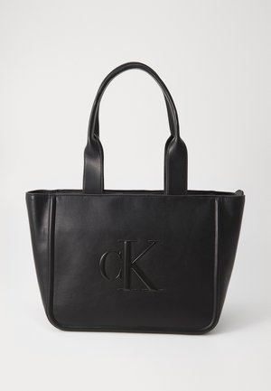 Juodas odinis rankinis krepšys su dviem rankenomis; turi įspaustą "cK" logotipą; stačiakampio formos; lygus paviršius; minimalistinis dizainas.