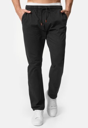 Pantalones jogger negros con cintura elástica, cordón, bolsillos laterales y puños ajustados. Fabricados con tejido suave, ideales para un uso casual.