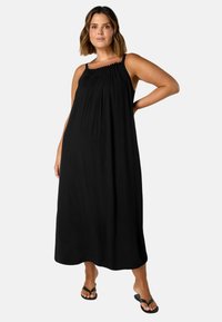 Schwarzes, ärmelloses Maxikleid mit Raffung am Ausschnitt; fließendes Design, leichtes Material und knöchellange Schnittform.