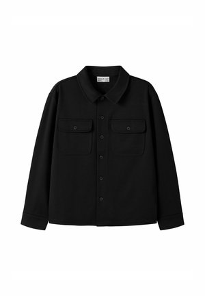 Chemise noire à manches longues avec boutons, col et deux poches poitrine avec rabats boutonnés, posée à plat sur un fond blanc.