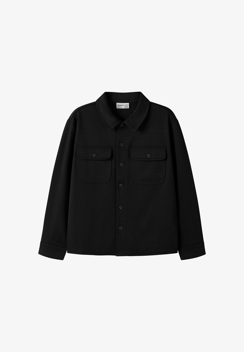 Chemise noire à manches longues avec boutons, col et deux poches poitrine avec rabats boutonnés, posée à plat sur un fond blanc.